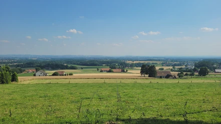 Weiter Blick über sanfte Hügel und Felder im Wiehengebirge, umgeben von verstreuten Bauernhöfen.