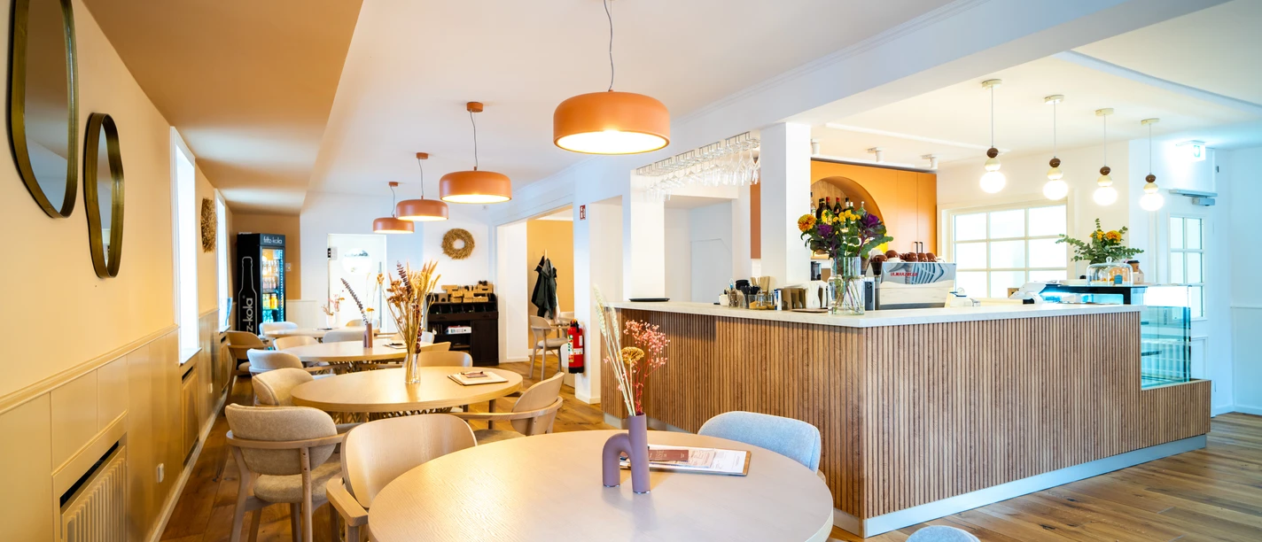 Nahé Café in Monheim am Rhein Modernes Café in Monheim am Rhein, mit stilvollen Holzmöbeln, warmem Licht und einladendem Ambiente.