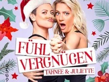 Zwei Frauen in festlicher Kleidung, eine mit Weihnachtsmannmütze, die andere mit Rentiergeweih.