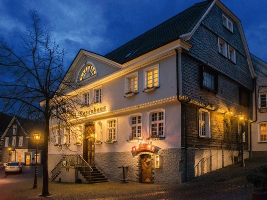 Hotel Rosenhaus in Velbert bei Nacht Historisches Hotel Rosenhaus in Velbert bei Nacht, beleuchtet, mit Fachwerk und einladender Eingangstür.