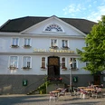 Hotel Rosenhaus in Velbert Das Hotel Rosenhaus in Velbert, ein historisches Gebäude, umgeben von Tischen auf einem gepflasterten Platz.