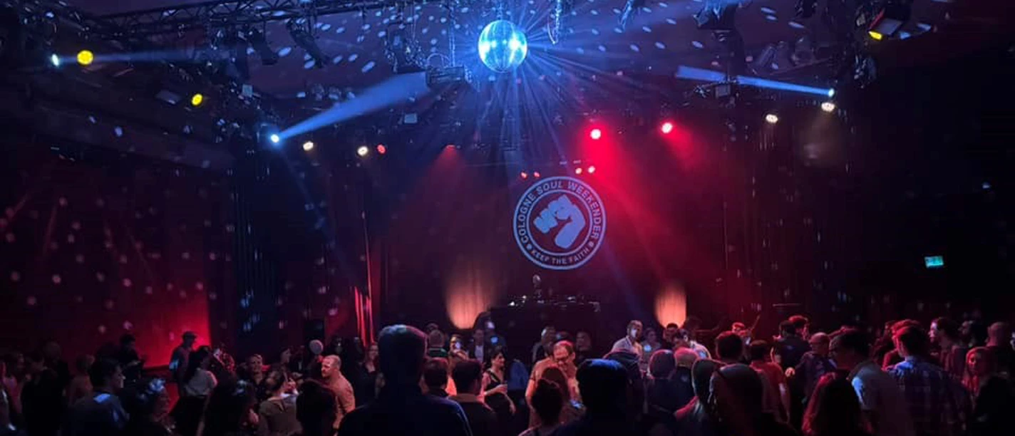 Cologne Soul Weekender Dancing crowd under a disco ball in front of the red and blue soul stage at the Cologne Soul Weekender