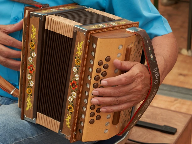 Schwyzerörgeli Mensch hält Schwyzerörgeli in der Hand