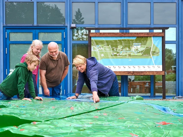 Familie schaut sich Plan im Natureum an