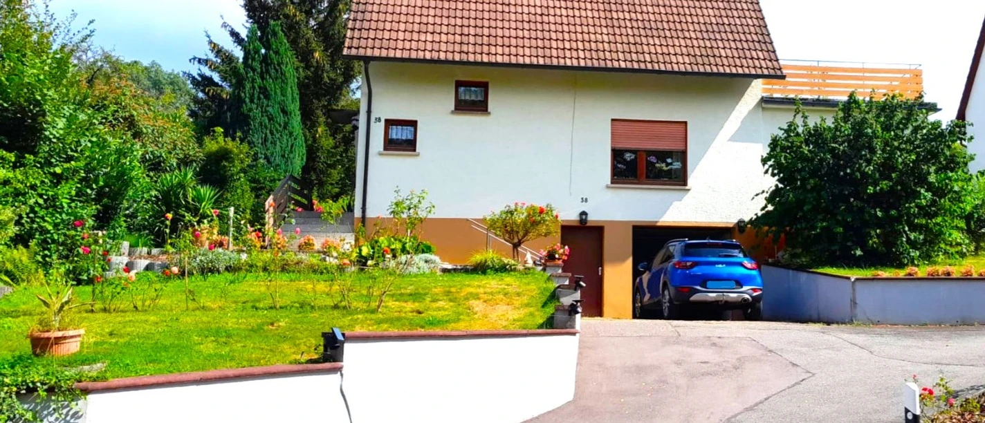 Außenansicht Haus Feicke mit Zufahrt und Garage und Sicht auf den Garten