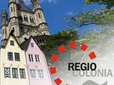 Kölner Altstadt mit farbenfrohen Giebelhäusern, im Hintergrund Groß St. Martin und blauer Himmel.