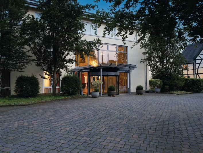 Eingang ins Ramada by Wyndham Düsseldorf Ratingen Der Eingang des Ramada by Wyndham Hotels in Düsseldorf Ratingen mit Glasdach und gepflastertem Vorplatz.