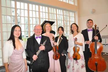 Staatsbad Orchester Bad Oeynhausen Sechs Musiker in festlicher Kleidung, mit Instrumenten in einem lichtdurchfluteten Raum.
