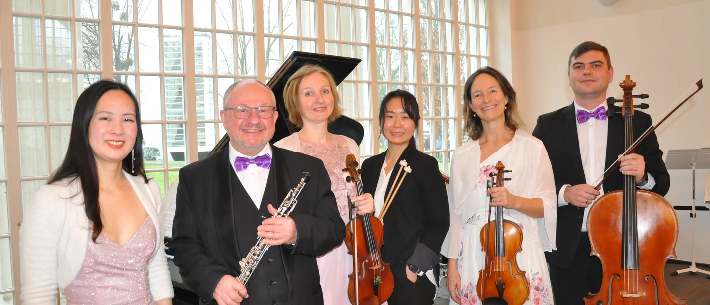 Staatsbad Orchester Bad Oeynhausen Sechs Musiker in festlicher Kleidung, mit Instrumenten in einem lichtdurchfluteten Raum.