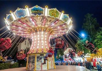 Rundfahrgeschäft im nostalgischen Stil, geschäftiger Zwiebelmarkt bei Nacht mit fröhlichen Besuchern.