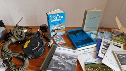 Historische Fluginstrumente, Atemmaske und Bücher zur Luftsportvereinigung Meschede auf einem Tisch.