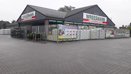 Wreesmann Sonderpostenmarkt.jpg Eingangsbereich des Wreesmann Sonderpostenmarkts mit Außenlager und Werbetafeln bei grauem Himmel.