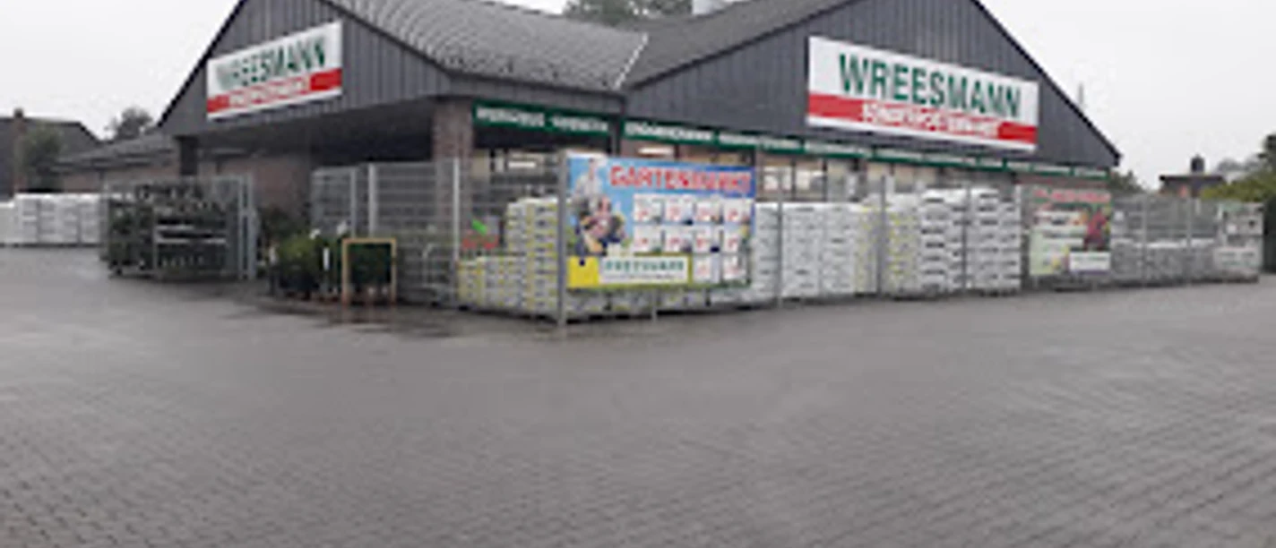 Wreesmann Sonderpostenmarkt.jpg Eingangsbereich des Wreesmann Sonderpostenmarkts mit Außenlager und Werbetafeln bei grauem Himmel.