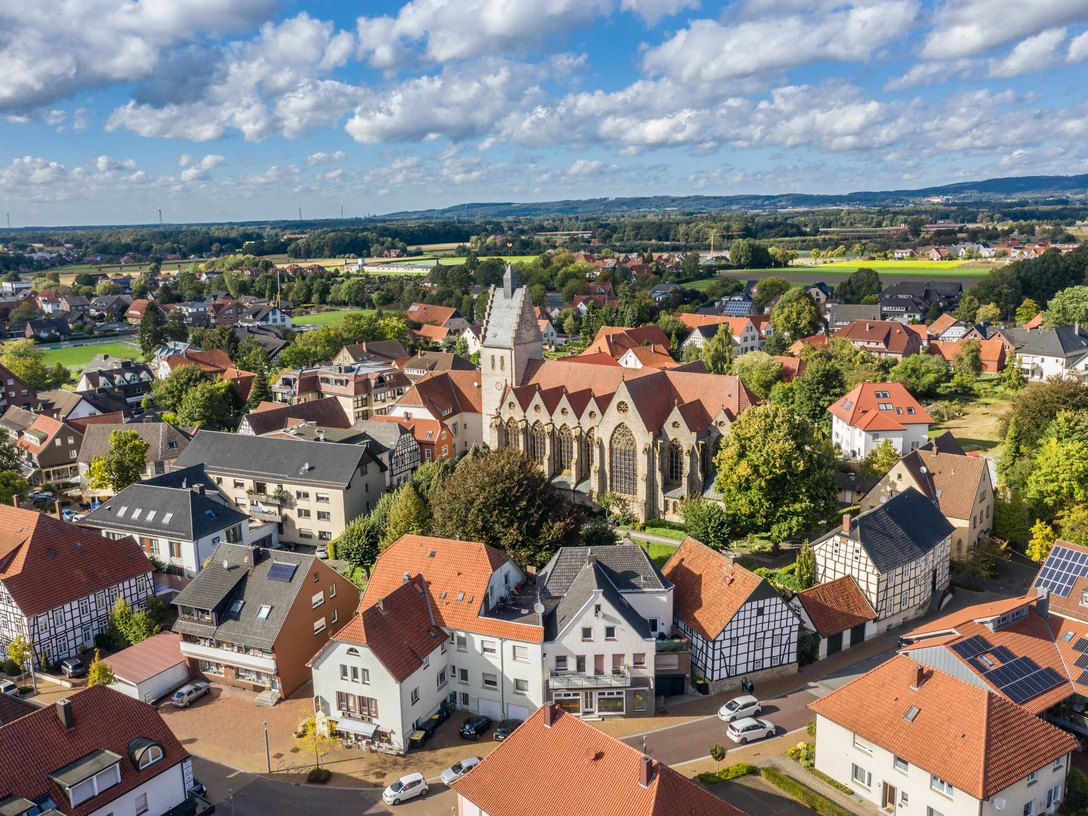 BadLaer_MaxWiesenbach.jpg Kirche im Zentrum einer beschaulichen Ortschaft, umgeben von Häusern und grüner Landschaft.Church in the center of a tranquil village, surrounded by houses and green countryside.Kirke i centrum af en rolig landsby, omgivet af huse og grønt landskab.Kerk in het centrum van een rustig dorp, omringd door huizen en een groen landschap.