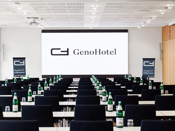 S 9 + S10 Conference room with parliamentary seating and a view of the screen with the inscription "Geno Hotel Forsbach"