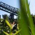 Wohnmobilstellplatz Landschaftspark Duisburg-Nord Das gezeigte Bild zeigt einen eindrucksvollen alten Industriekran, umgeben von grüner Natur.