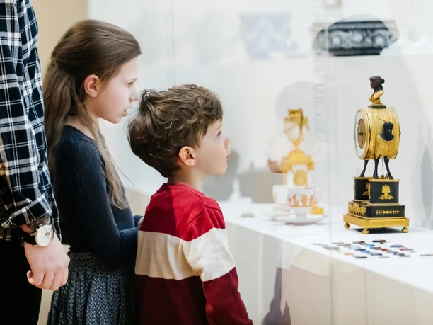 GRASSI Museum für Angewandte Kunst Zwei Kinder betrachten eine historische Uhr in der Ausstellung des GRASSI Museums für Angewandte Kunst am Johannisplatz in Leipzig