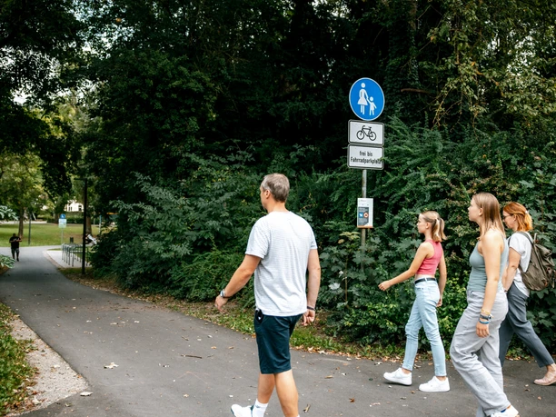 Familie geht in der grünen Natur spazieren.