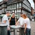 Einbecker Bierpfad Vier Personen betrachten ein Fass des Bierpfades auf dem Einbecker Marktplatz.