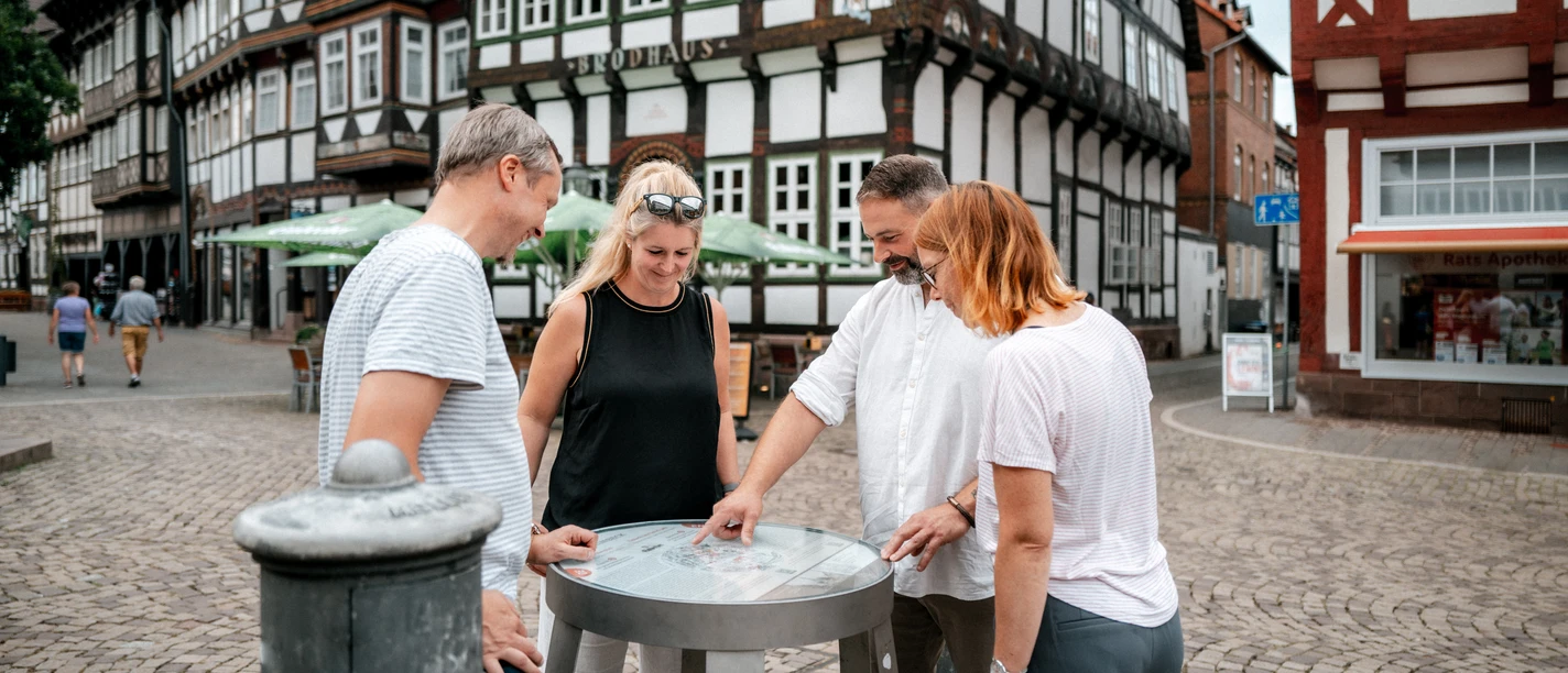 Einbecker Bierpfad Four people look at a barrel on the beer trail on Einbeck's market square.