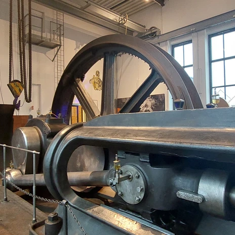 KohleWelt 4 Historische massive Maschine in einer Kohleabbau-Ausstellung mit beleuchteter Wandaufschrift.