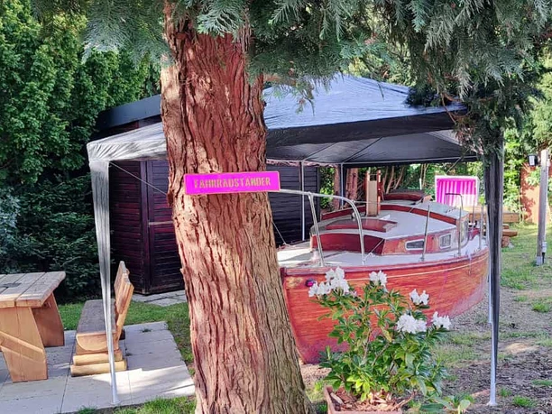Columbus Hotel und Glamping Garten mit Boot Anni und Sitzmöglichkeiten