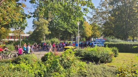 Sieben Pässe Tour Eine große Gruppe von Radfahrern versammelt sich bei sonnigem Wetter im Grünen für die Sieben Pässe Tour.