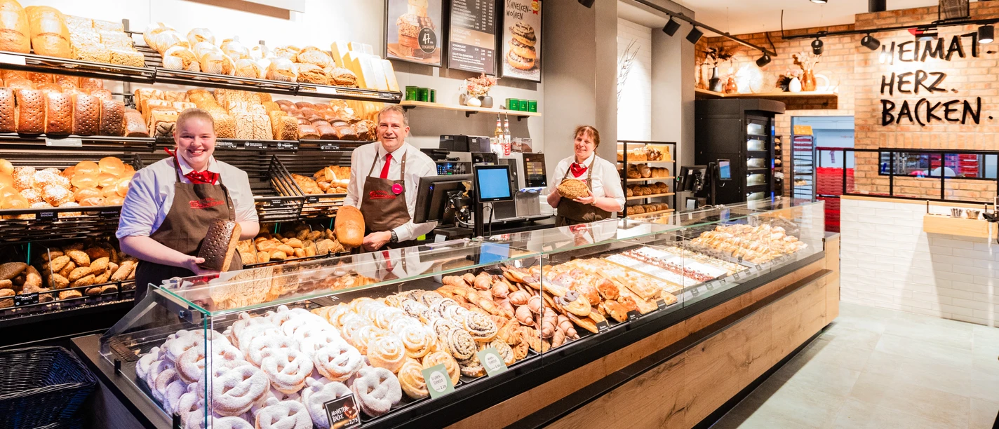 Bertermann-Minden-31.10.23-030(1).jpg Das Bild zeigt den Tresenbereich einer Filiale mit den Verkaufsprodukten und drei Mitarbeitern.