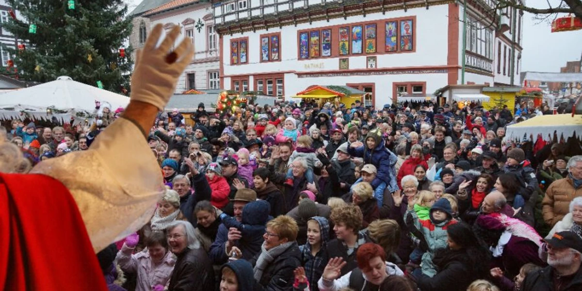 termine-sint-nicolaas-markt-weihnachtsmarkt-blomberg-900x600.jpg Menschenmenge vor Fachwerkgebäude beim Sint Nicolaas Markt in Blomberg, im Vordergrund Nikolas.