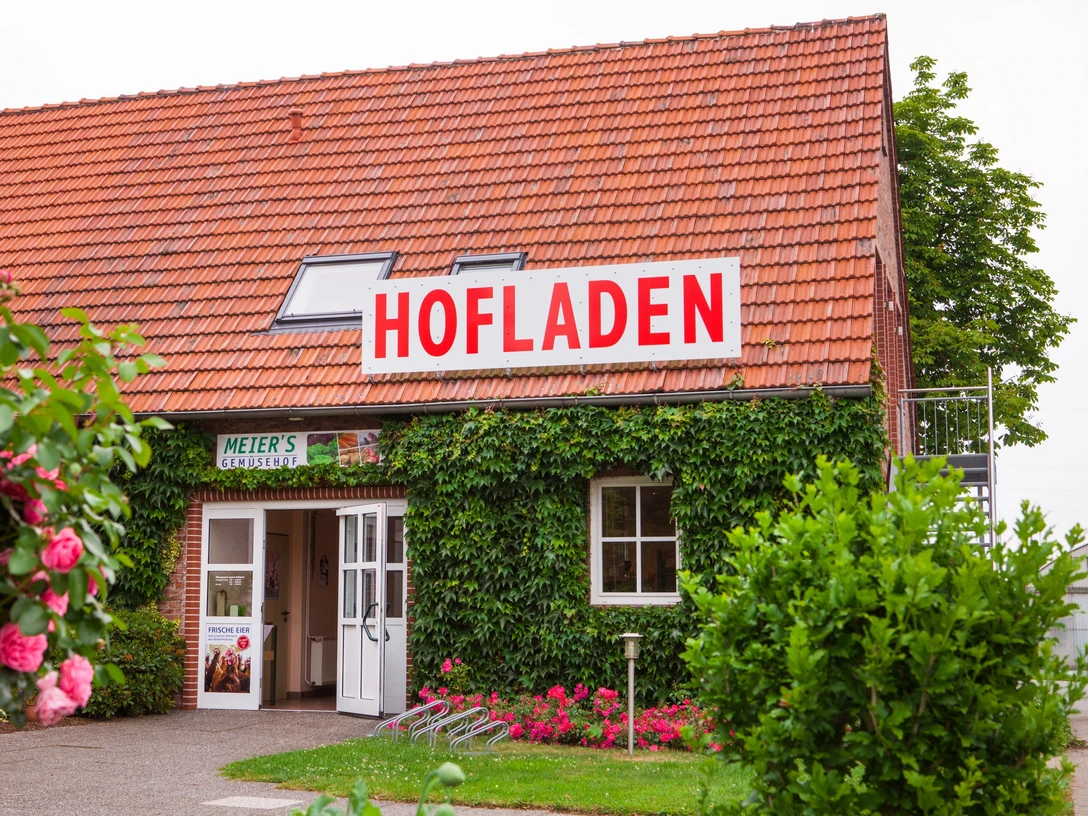 Meier's Gemüsehof Meier's Gemüsehof zeigt einen roten Ziegeldachbau mit begrünten Wänden und hofladenschild.