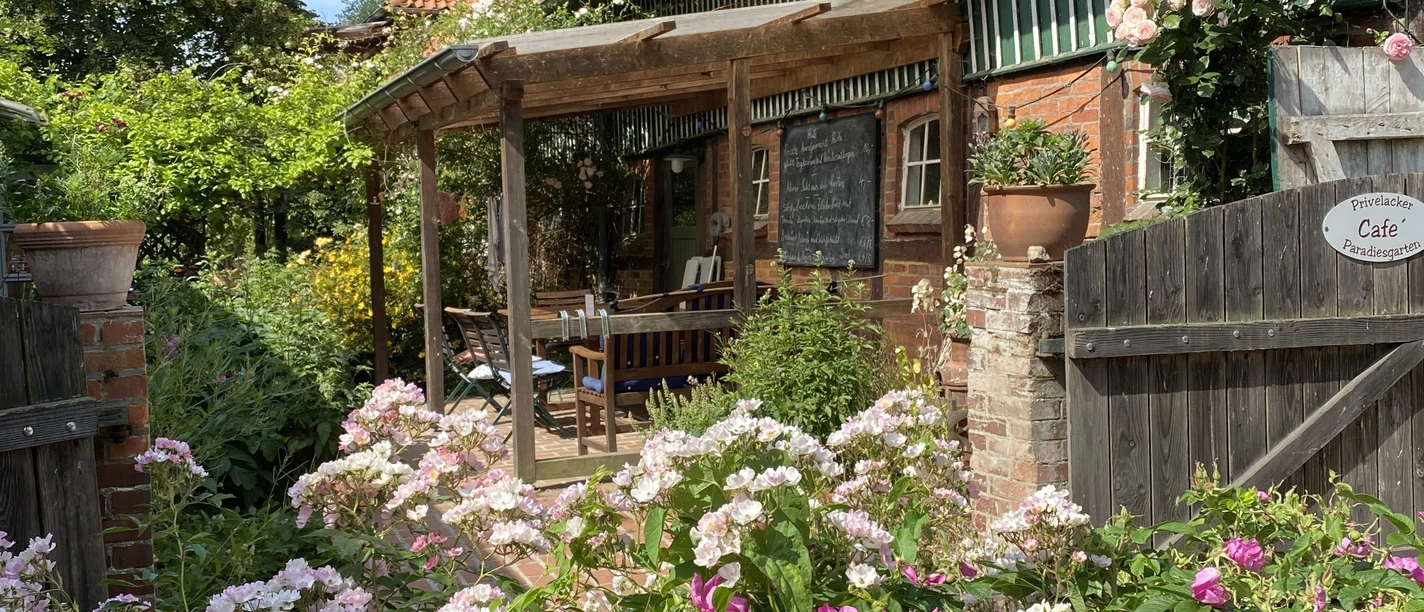 Ingang tot het café Ingang naar het café met bloeiende zomertuin