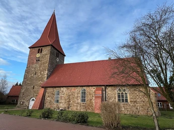 St. Bartholomäus Kirche Balge Die St. Bartholomäus Kirche in Balge aus rotem Backstein mit markantem Turm und roten Dachziegeln.