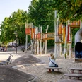 Wasserspielplatz Emssee Wiedenbrück 2 Moderner Spielplatz mit bunten Klettergerüsten, Rutsche und Sandfläche, umgeben von grünen Bäumen.