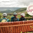 Mountainbiker sitzen auf einer Bank mit Ausblick