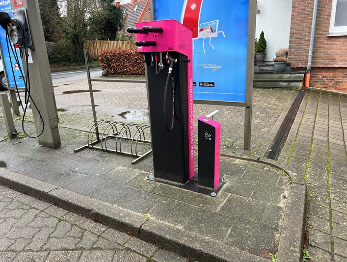 Rad-Servicestation Kirchlinteln Rad-Servicestation mit Werkzeugen und Luftpumpe auf Gehweg. Hintergrund: Straßenszene, Gebäude.