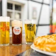 Zollhäuschen Kneipe Drei köstliche, frisch gezapfte Biere in unterschiedlich hohen, schlanken Gläsern vor Fachwerkhaus.