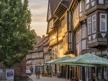 Fachwerk am Marktplatz Fachwerkhäuser und Menschen, die im Außenbereich eines Restaurants sitzen auf dem Marktplatz bei Abendsonne.