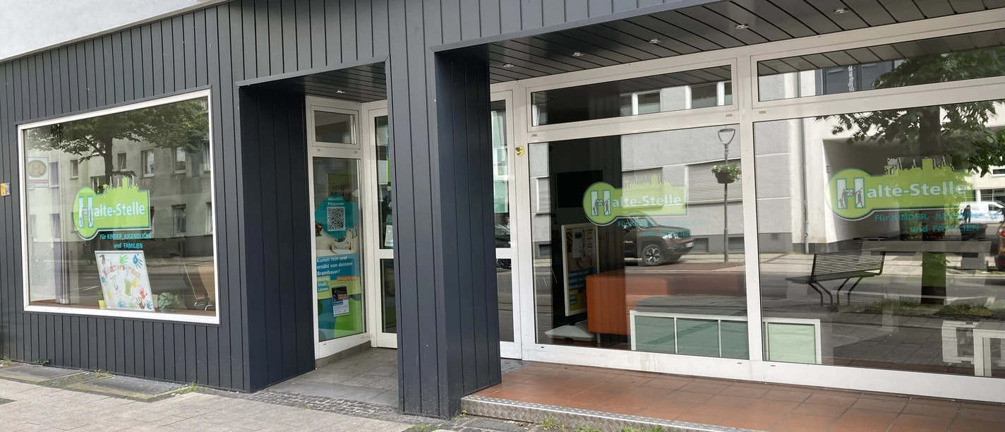 Halte-Stelle Brambauer Modernes Ladenlokal mit großen Schaufenstern und Zugangsstufen an der Frontansicht.
