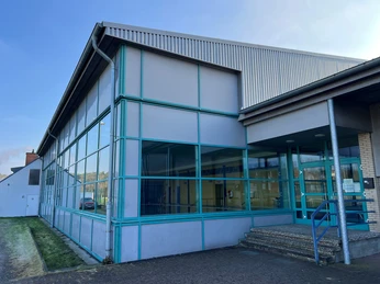 Hallenbad Steimbke Das Hallenbad Steimbke mit seiner markanten blauen Fassade und breiten Glasfront für viel Tageslicht.