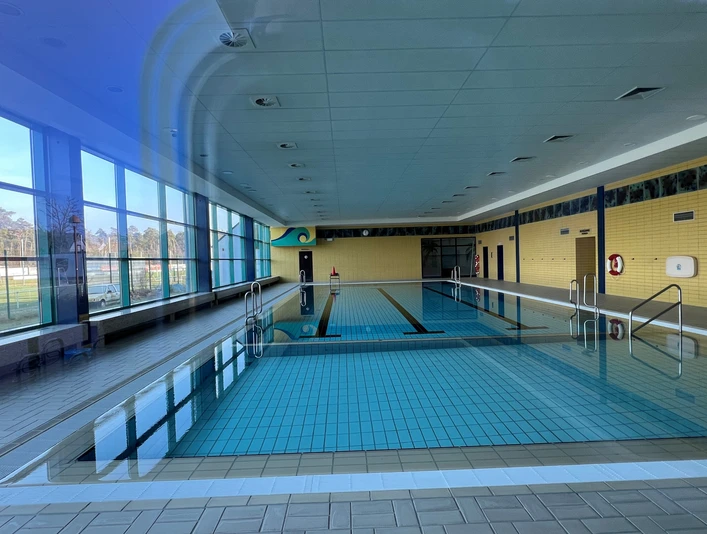 Das Hallenbad Steimbke hat ein großes Becken mit modernen Glasfronten und beige gefliesten Wänden.