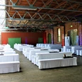 Herford-Alter Güterbahnhof-Events-Pro Herford GmbH (3).JPG Ein großzügiger Veranstaltungsraum im alten Güterbahnhof mit weißen Tisch- und Bankbezügen.