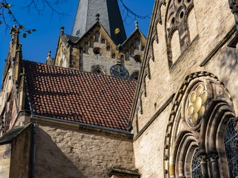 Herford_Münsterkirche im Herbst_Pro Herford GmbH.jpg Die Münsterkirche in Herford mit Kirchturm, herbstlich beleuchteter Fassade und verzierten Fenstern.