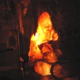 salgrotte-revital-bad-zwischenahn1.jpg Ein stimmungsvoll beleuchteter Raum mit einer Salzkristallformation und Liegen im Dunkeln.