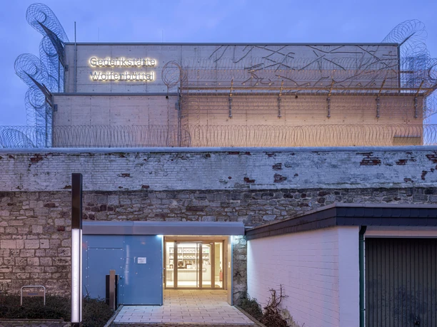 Gedenkstätte-JVA-WF-Eingang.jpg Wolfenbüttel memorial, stone building with barbed wire, open entrance