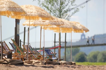 Minden - Weserstrand.JPG Das Bild zeigt den Mindener Weserstrand mit Strandliege und Sonnenschirm.