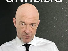 Porträt von "Der Graf", dem Sänger der Band Unheilig, in weißem Hemd, ernster Blick, dunkelem Hintergrund.