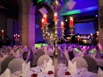 20170930-IMG_0477.jpg Bankettbestuhlung in weiß mit gedeckten Tischen und großen Kerzenständern als TischdekoBanquet seating in white with laid tables and large candlesticks as table decorations