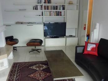 Wohnzimmer mit Flachbild-Fernseher und ausklappbarem Bett