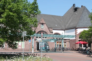 Herford Hauptbahnhof_Pro Herford GmbH.jpg Historischer Haupteingang des Herforder Hauptbahnhofs mit Fahrradständern und angrenzendem Café.