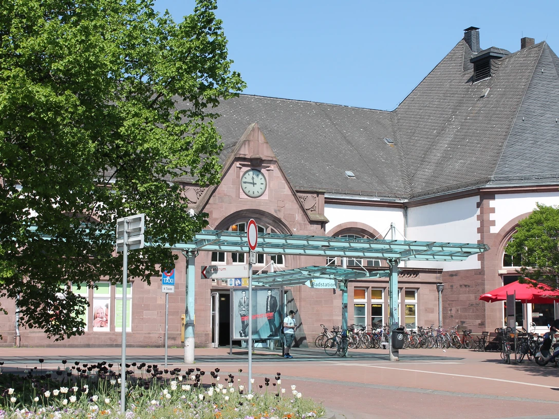 Herford Hauptbahnhof_Pro Herford GmbH.jpg Historischer Haupteingang des Herforder Hauptbahnhofs mit Fahrradständern und angrenzendem Café.